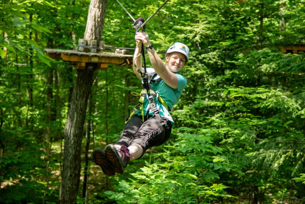 Jeune femme faisant le parcours dans les arbres et la tyrolienne au parc Arbraska, à Rawdon, dans Lanaudière