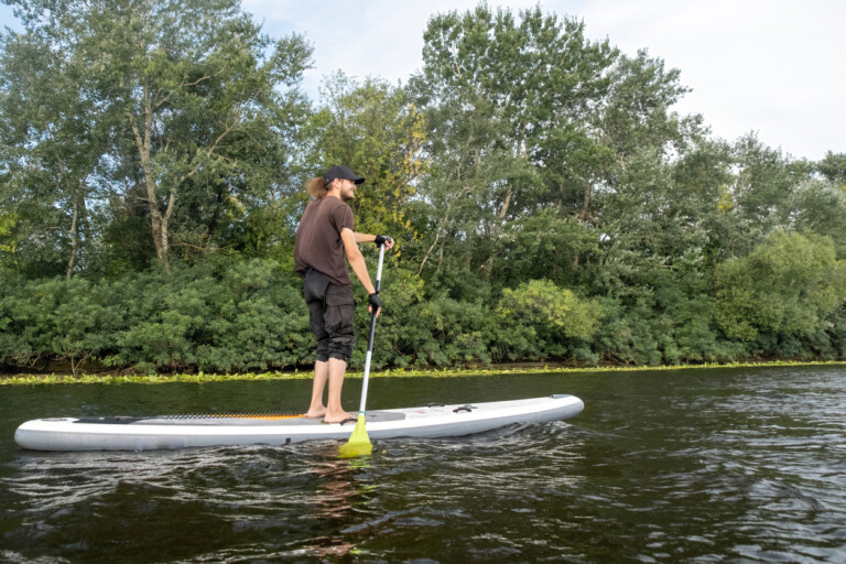 Jeune homme faisant du paddle board sur un lac