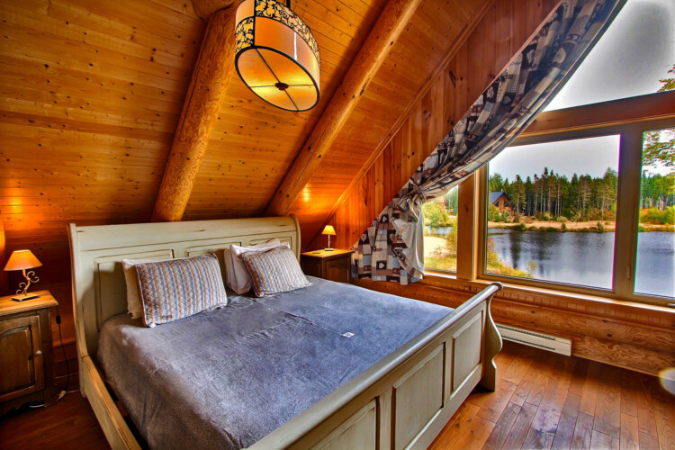 Chambre avec vue sur le lac du chalet en location Chalet les Marmottes dans la région de Québec, chalet bord de l'eau à Sainte-Christine-d'Auvergne.