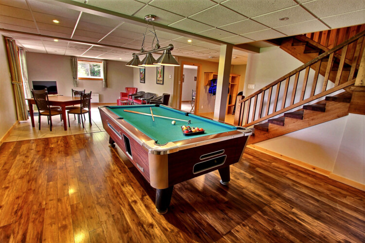 Table de billard avec espace jeux au sous-sol du chalet à louer Chalet les Marmottes dans la région de Québec, chalet bord de l'eau à Sainte-Christine-d'Auvergne.