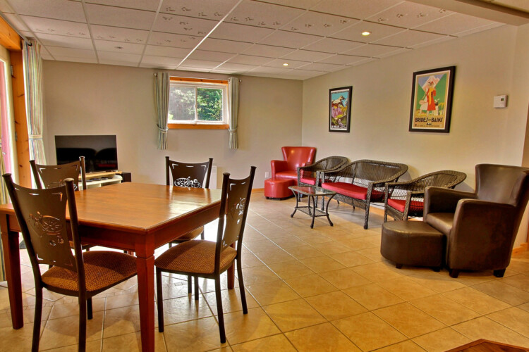 Salon au sous-sol avec table de jeux du chalet en location Chalet les Marmottes dans la région de Québec, chalet bord de l'eau à Sainte-Christine-d'Auvergne.