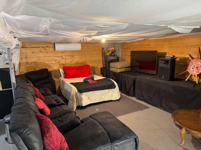 Salon et lit au sous-sol du chalet à louer Domaine du ranch Privé en Mauricie, chalet avec spa à Sainte-Ursule