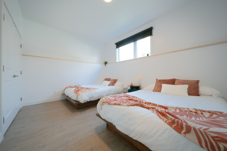 Grande chambre avec deux lits du chalet en location Le Mëlyā en Estrie, chalet avec foyer au bois à Weedon.