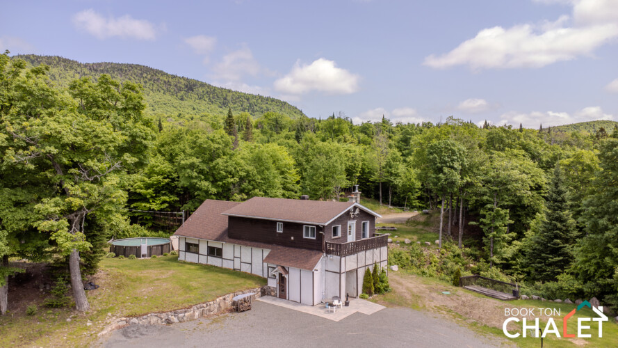 Façade vue en vol d’oiseau du Chalet à louer Le Suisse en Laurentides, chalet à louer avec piscine à Val-des-lacs