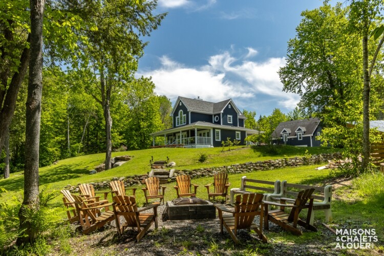 Coin à feu avec chaises Adirondack du Chalet en location Le Grand Duc en Estrie, chalet au bord de l'eau avec spa à Lambton.