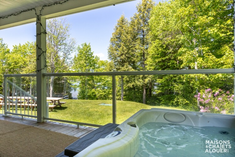 Spa sur la gallerie du Chalet à louer Le Grand Duc en Estrie, chalet au bord de l'eau avec spa à Lambton, sur le site de Chalet à Rabais.