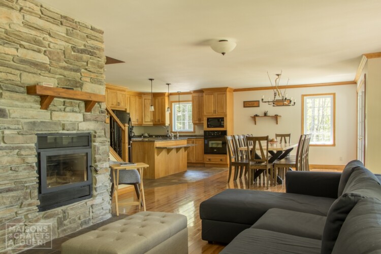 Foyer au bois en pierres du Chalet en location Le Grand Duc en Estrie, chalet au bord de l'eau avec spa à Lambton.
