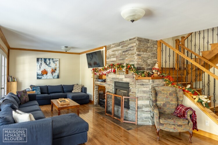 Salon agrémenté d'une guirlande de Noel au Chalet à louer Le Grand Duc en Estrie, chalet au bord de l'eau avec spa à Lambton.