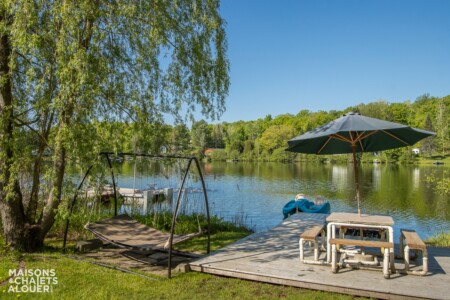 Quai et table à pique-nique et hamac du Chalet à louer La Siesta à Lanaudière, chalet situé au bord de l'eau avec spa à Saint-Calixte.